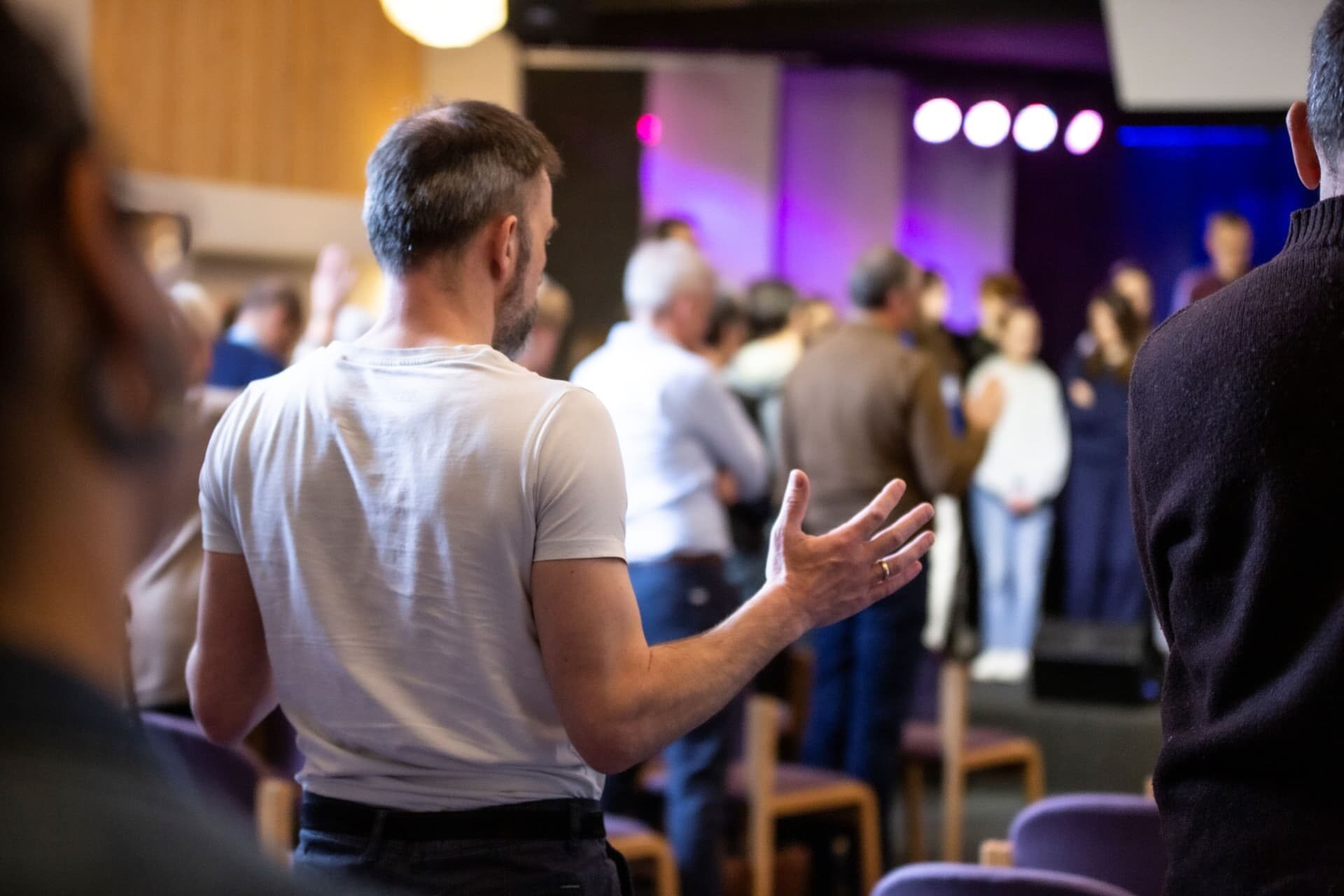 A man raising his hand during worship at Bykirken
